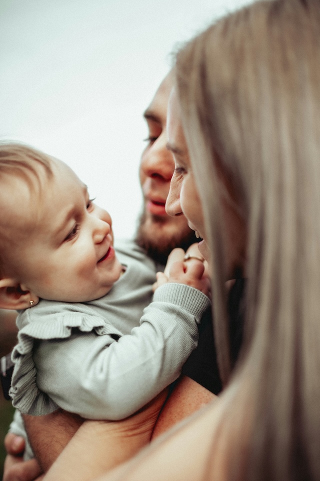 a man and woman holding a baby